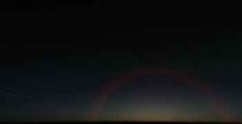Aurora and Ice halo. The sun is below the horizon. The rays of the low sun are red. making the halo red. FlightGear 2020.x.