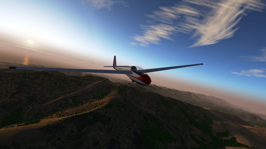 Ein Segelflugzeug Schleicher ASK 13 fliegt über Korsika bei Sonnenaufgang